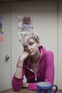 Portrait of mid adult woman sitting on table