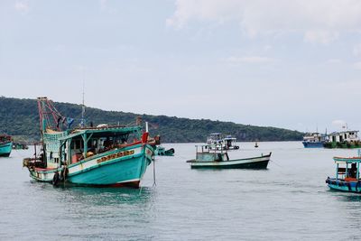 Boats sailing in sea against sky