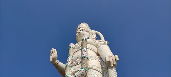 Low angle view of statue against blue sky