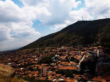 Aerial view of townscape and mountains against sky