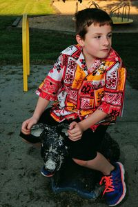 Boy sitting on equipment at playground