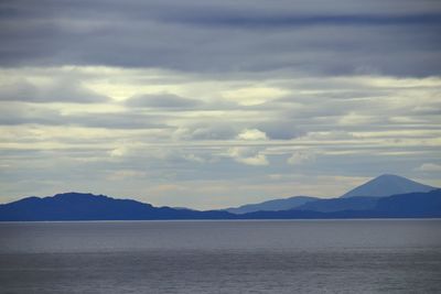 Scenic view of sea and mountains against sky