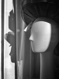 Side view of woman standing against wall at home