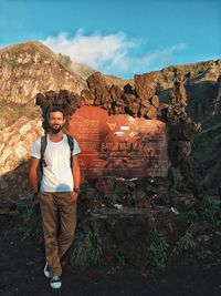 Portrait of man standing against rock