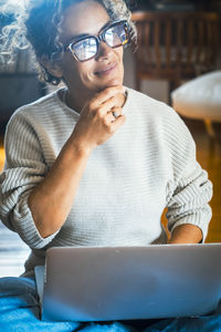 Midsection of woman using mobile phone while sitting at home