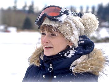 Close-up of smiling woman in warm clothing standing outdoors