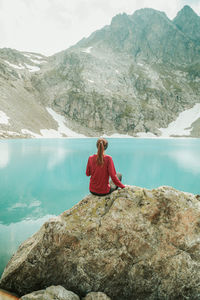 Full length of young woman on rock by lake