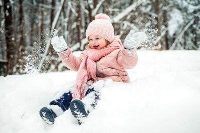 Cute girl playing with snow during winter