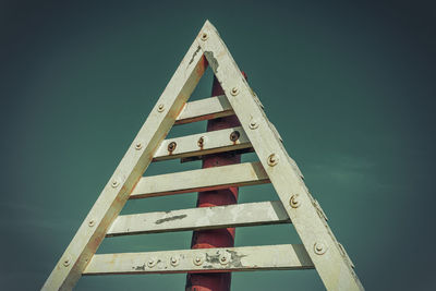 Low angle view of text on wood against sky