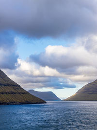 Scenic view of sea and mountains against sky