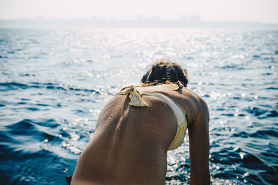 Rear view of young woman looking at sea shore