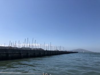 Sailboats in sea against clear blue sky