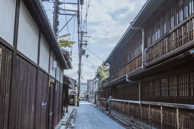 Road amidst buildings in city against sky