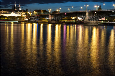 Illuminated bridge over river at night