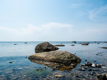 Rocks in sea against sky
