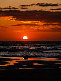 Scenic view of sea against orange sky