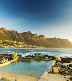 Scenic view of sea and mountains against sky