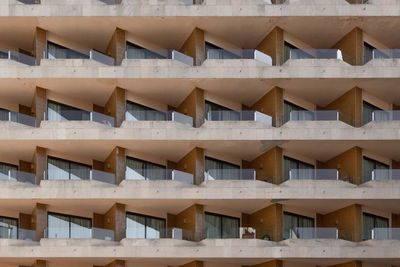 Full frame shot of repeating pattern with windows and balcony on a bulding front