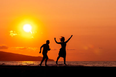 Silhouette of two persons in sunset, love and dancing, having fun.