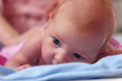 Close-up of cute baby boy lying on bed