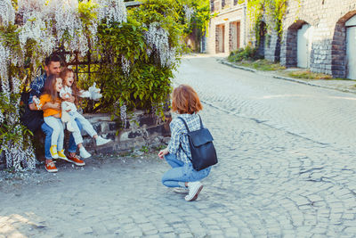 Rear view of women sitting on floor