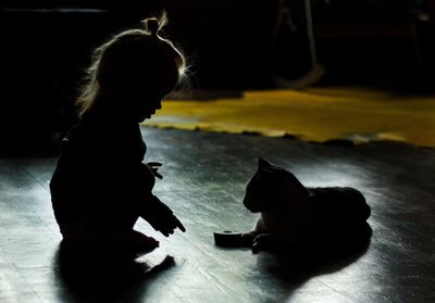 Woman with dog sitting on floor