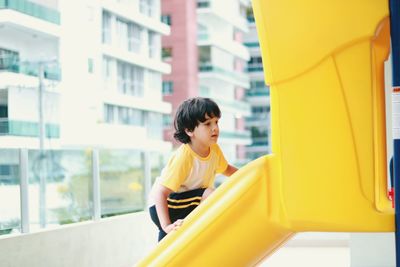 Rear view of boy looking at window