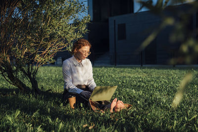 Businesswoman working on laptop in park