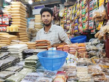 Portrait of young man holding ice cream at market