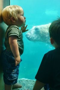 Full length of man and fish in aquarium