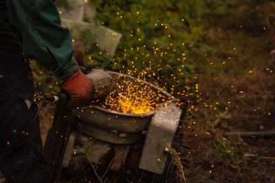 Midsection of man using circular saw on metal