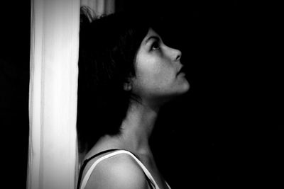 Close-up of girl looking up in darkroom