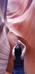 Rear view of woman standing on rock