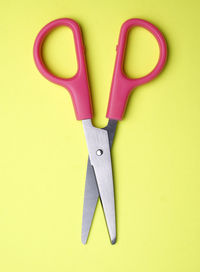 Directly above shot of scissors on yellow background