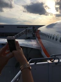 Midsection of man using mobile phone against sky