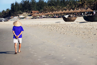 Rear view of boy walking on beach