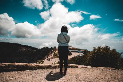 Rear view of woman standing against sky