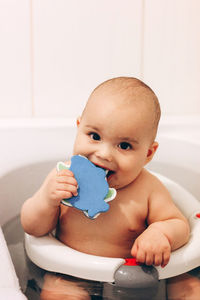 Portrait of cute baby girl sitting at home