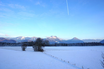 Scenic view of frozen lake against blue sky