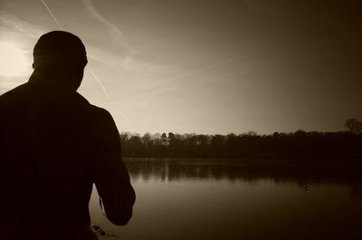 Silhouette of man in water at sunset