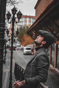 Side view of young man on street in city