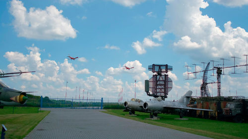 Airplane flying over airport runway against sky