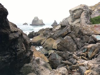 Rocks on beach against sky