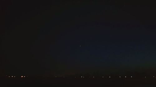 Aerial view of illuminated city against clear sky at night