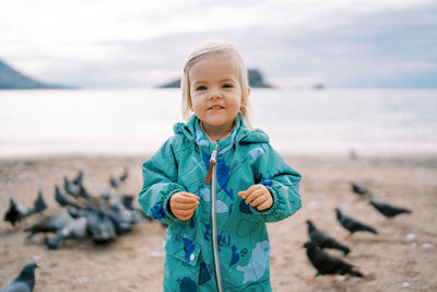 Portrait of young woman standing at beach