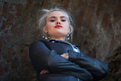 Portrait of young woman standing with arms crossed