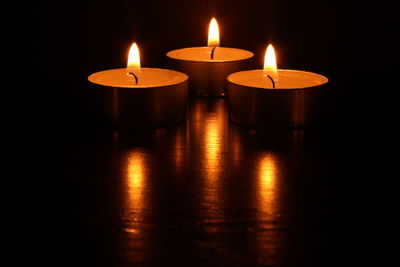 Close-up of illuminated candles on table