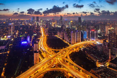 High angle view of illuminated cityscape against sky at night