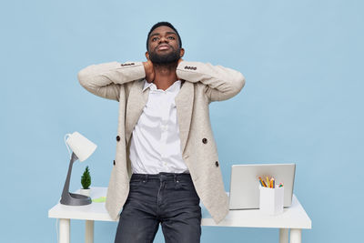 Low angle view of man standing against blue background