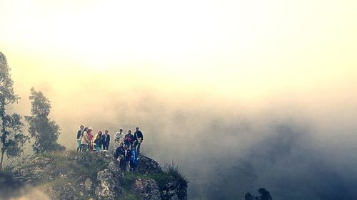 People on mountain against sky